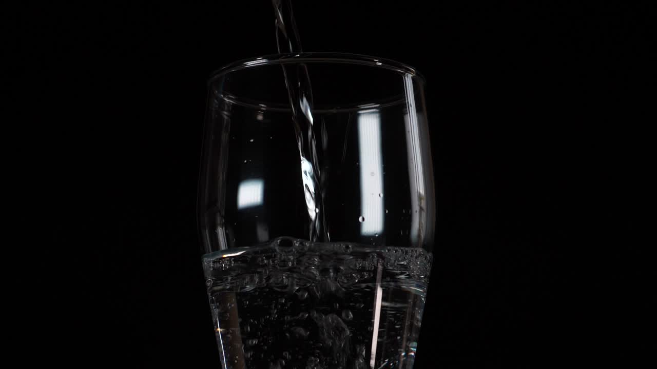 Water pouring, liquid hydration, clear transparent glass, ripple motion