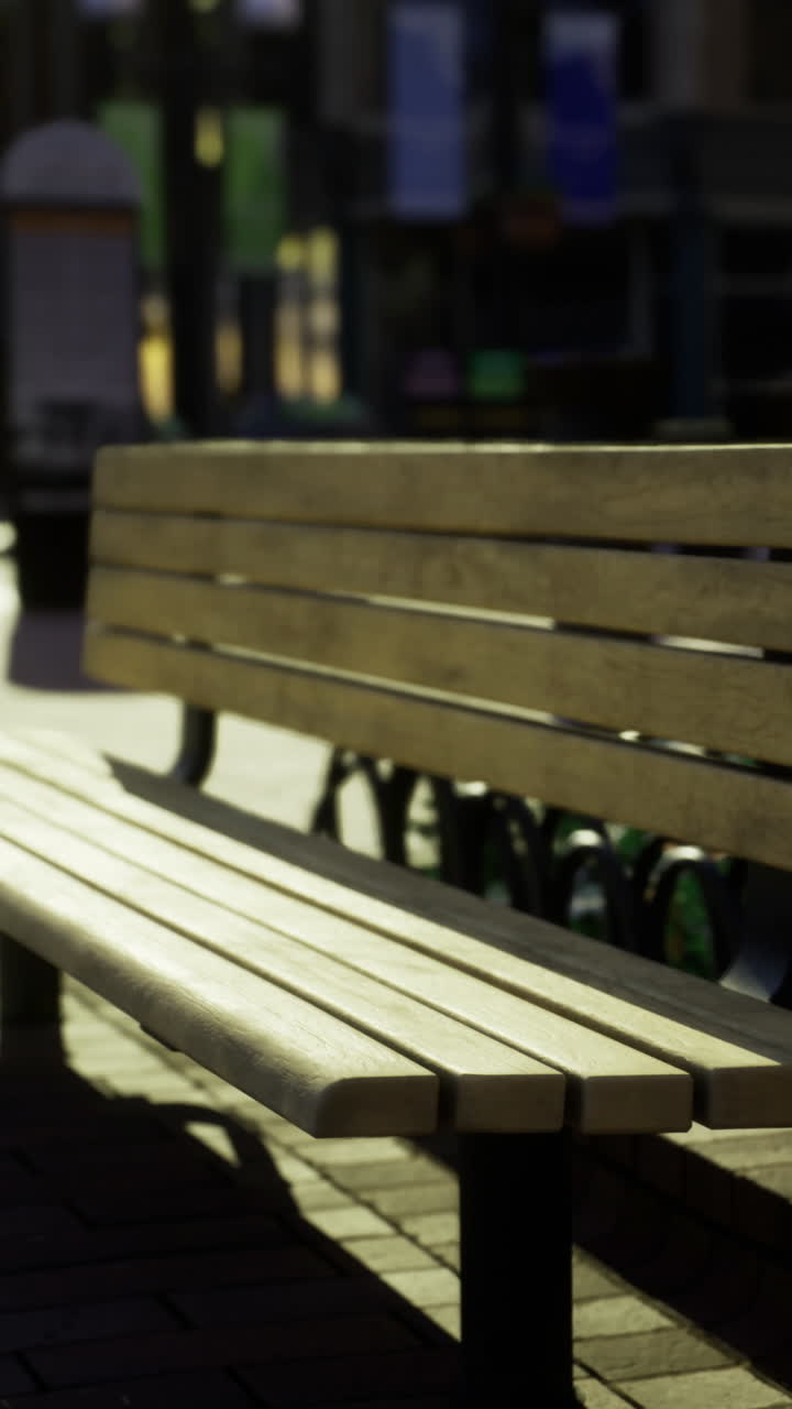 Wooden bench in urban area during afternoon sunlight in a bustling city