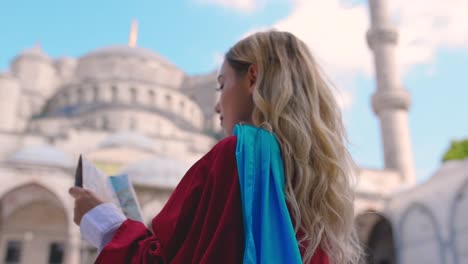 slow motion:attractive beautiful girl looks at map of istanbul with view of sultan ahmet mosque in istanbul,turkey