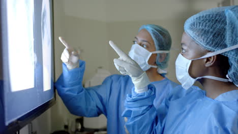 diverse surgeons examine an x-ray in a hospital operating theatre, with copy space