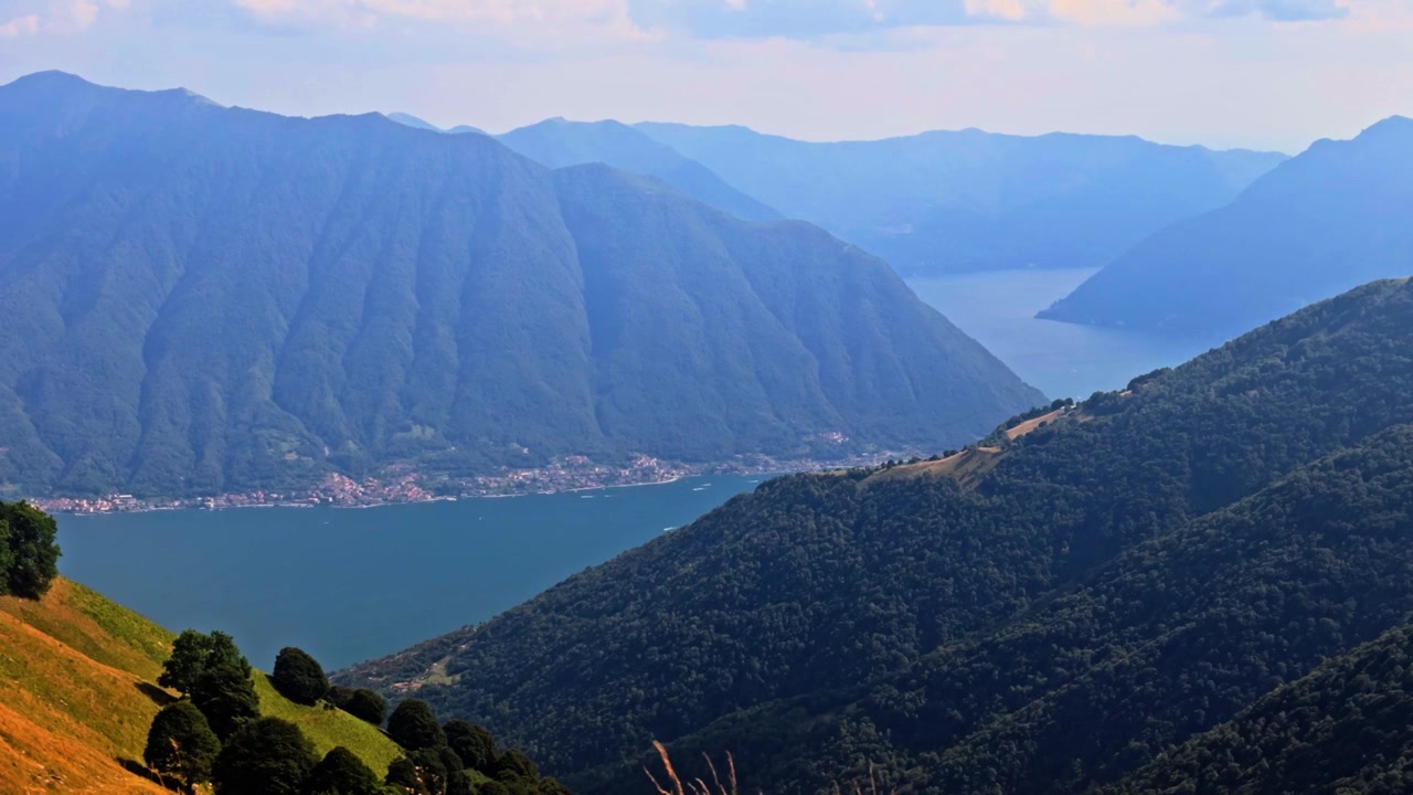 Splendida vista aerea delle maestose montagne che circondano il Lago di Como in Italia. La città di Tremezzina si trova sulla pittoresca riva.