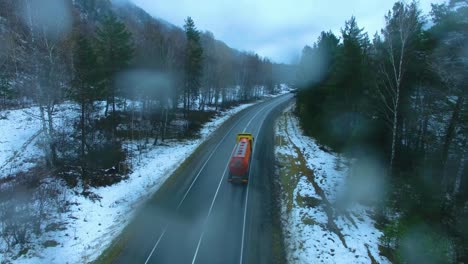 snowy mountain road with truck on a rainy day