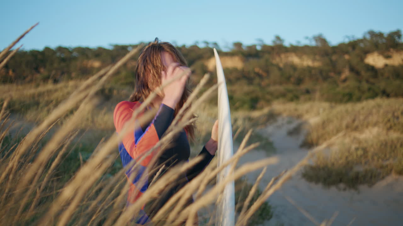 Surf girl posing nature looking camera at coast portrait. Sport people lifestyle