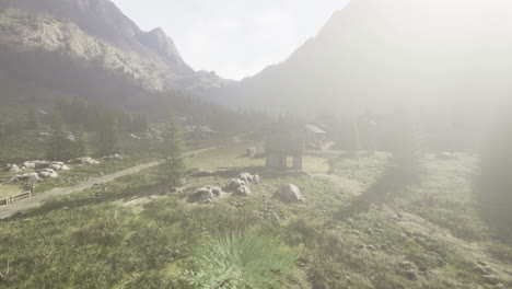 mountain landscape with sunlit fog and winding dirt path in the distance
