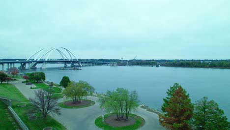 Two-Excavators-on-floating-dock-pontoon-on-mississippi-river-at-Centennial-Bridge-in-Davenport,-Iowa,-USA