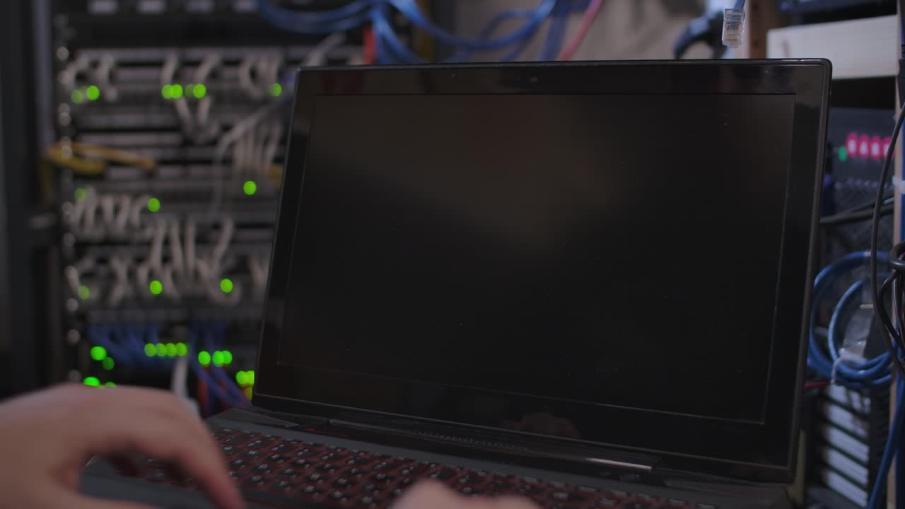 손이 흐릿한 서버 시스템 배경에 대해 노트북 컴퓨터를 엽니다.