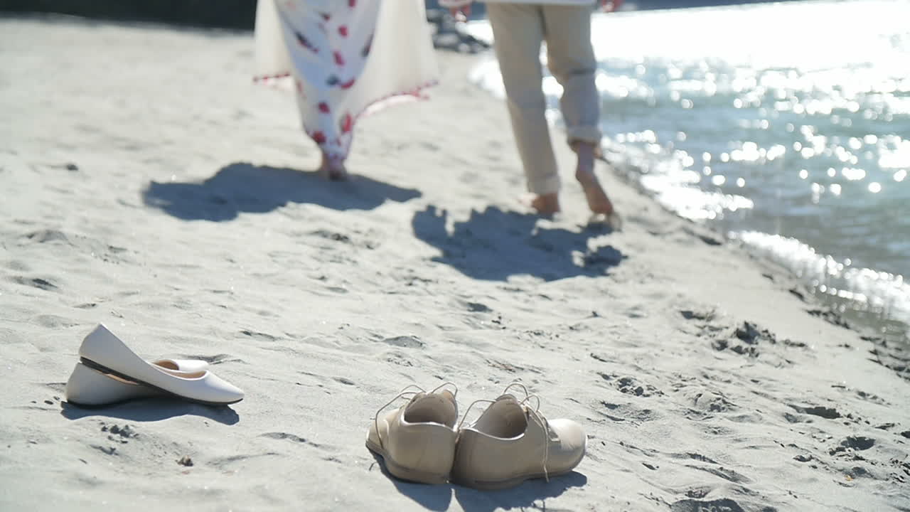 Пара гуляет по пляжу.