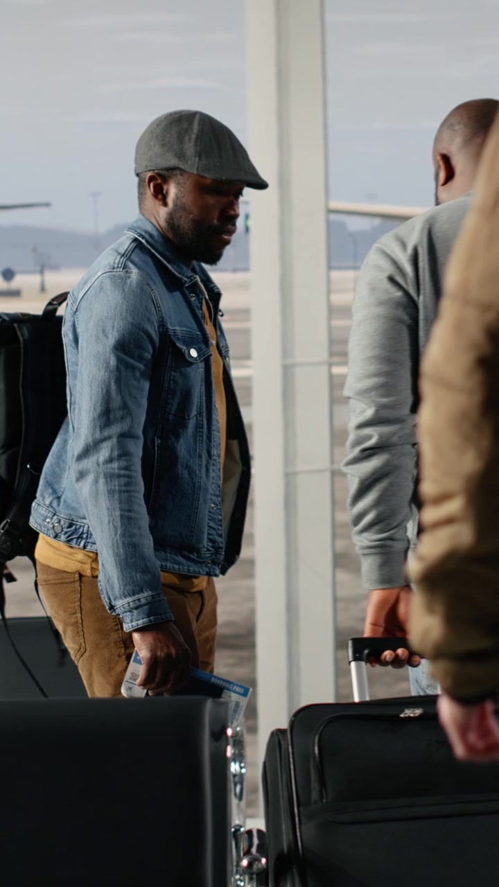 Diverse Travelers Walking with Luggage in a Busy Airport Terminal