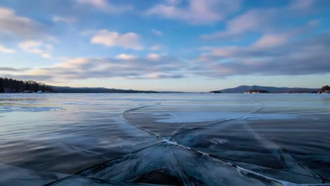 a serene winter landscape: ice patterns and reflections on a tranquil lake under a colorful sky at dusk, capturing nature's instinctive beauty in frosty splendor