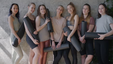Women holding yoga mats smiling