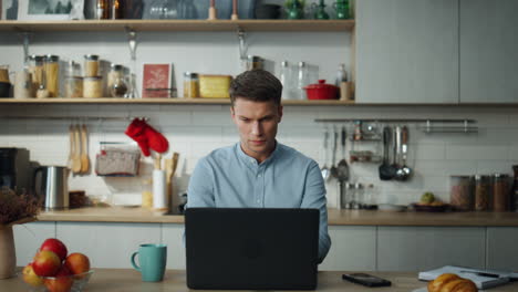 Hombre-De-Negocios-Abriendo-Una-Computadora-Portátil-Comenzando-A-Trabajar-En-La-Cocina-De-Casa.-Empleado-Independiente.