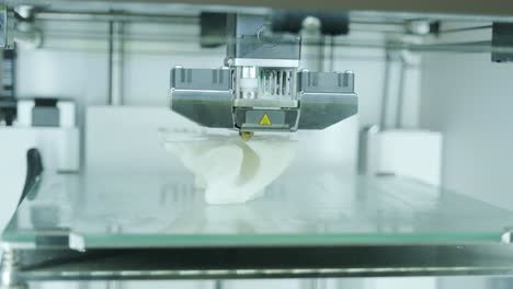 la moderna impresora 3d imprime figuras de primer plano macro. la impresora tridimensional automática 3d realiza el modelado de colores blancos de plástico en el laboratorio. el procesamiento de impresión 3d con fondo blanco