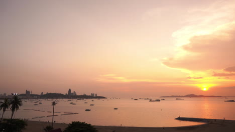 Una-Impresionante-Puesta-De-Sol-De-Color-Rosa-Dorado-Sobre-La-Bahía-De-Pattaya-Ilumina-Los-Barcos-Atracados-Que-Flotan-En-Aguas-Tranquilas-Mientras-Las-Farolas-Comienzan-A-Encenderse