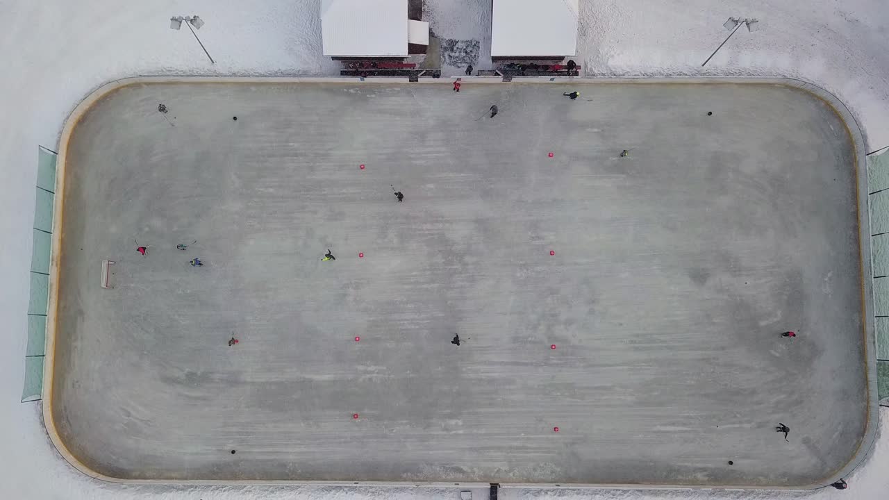 알아볼 수 없는 사람들과 함께 아이스하키 코트 위로 날아가는 공중 조감도