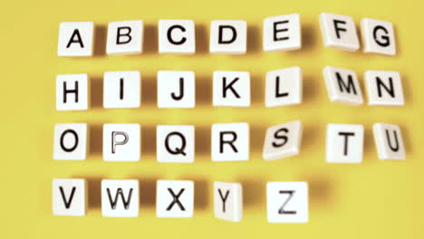 plastic letters bouncing and showing alphabet on yellow surface