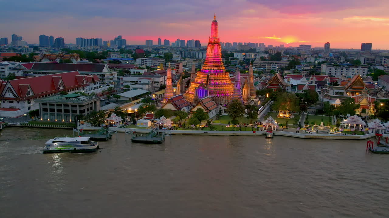Drone sobre o templo Wat Arun e pôr do sol no horizonte de Bangkok