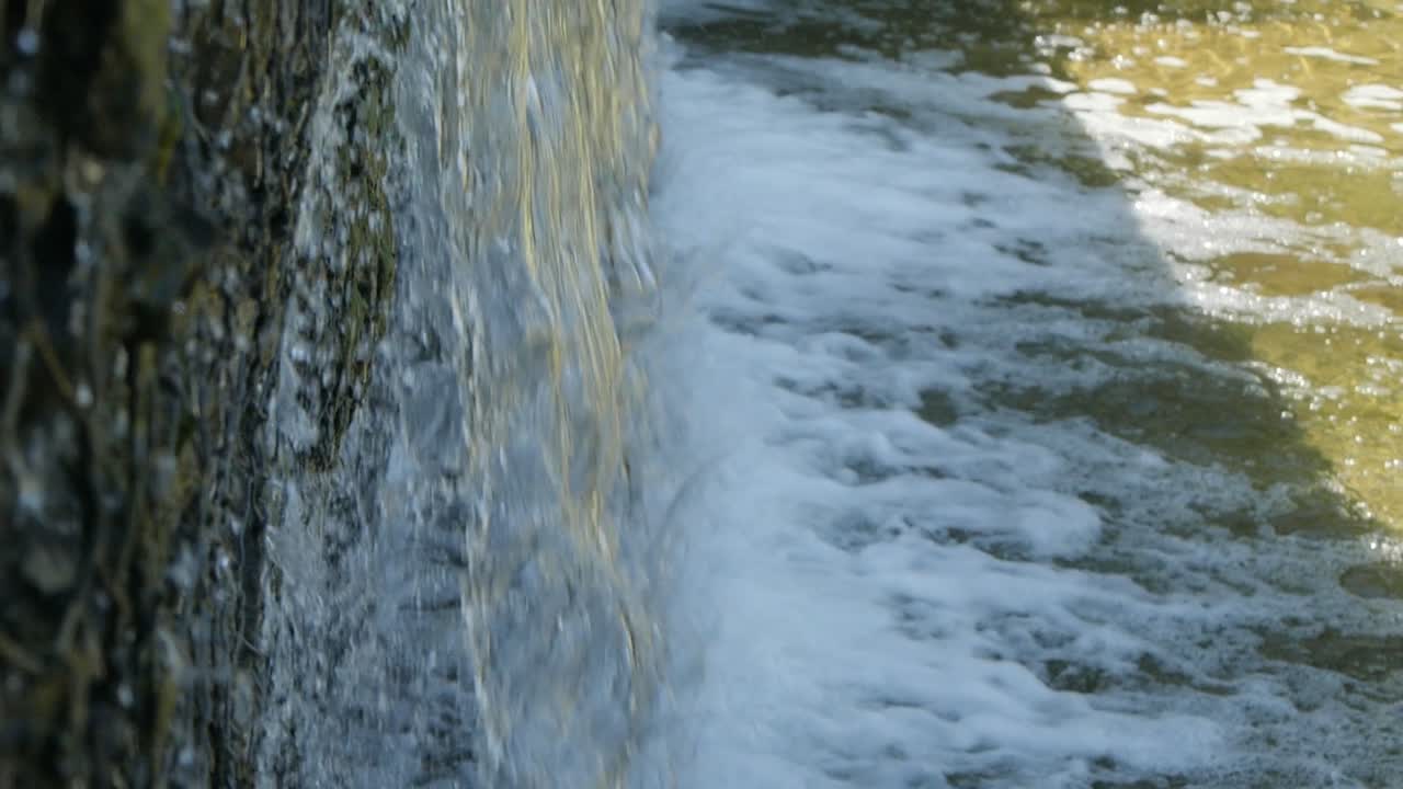 바위 벽에 부혀 강으로 떨어지는 폭포 아래로 떨어지는 물의 근처