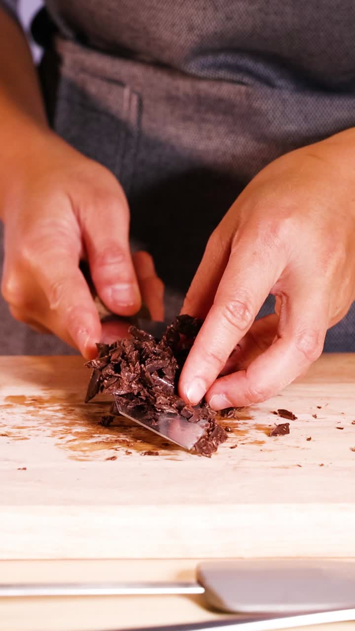 persona cortando discos de chocolate en pedazos más pequeños