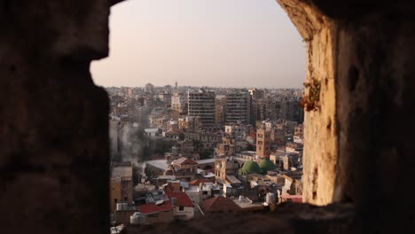 view looking through an old stone window down towards old town of tripoli, northern lebanon