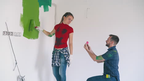 man-proposes-with-ring-to-emotional-girl-in-light-room