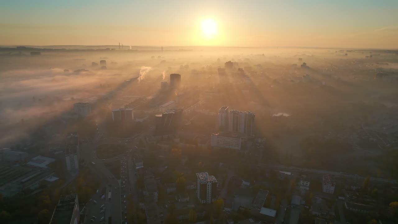 Aerial drone view of Chisinau at sunrise, Moldova. View of the city with fog in the air, multiple buildings, streets with yellowed trees