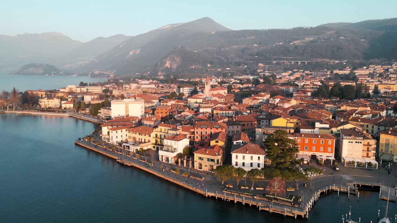 Aerial view city Iseo in Italy. Small town on Iseo Lake, tourist destination in Italian north in the mountains Alps. Drone flight on lake shore harbor with small town background