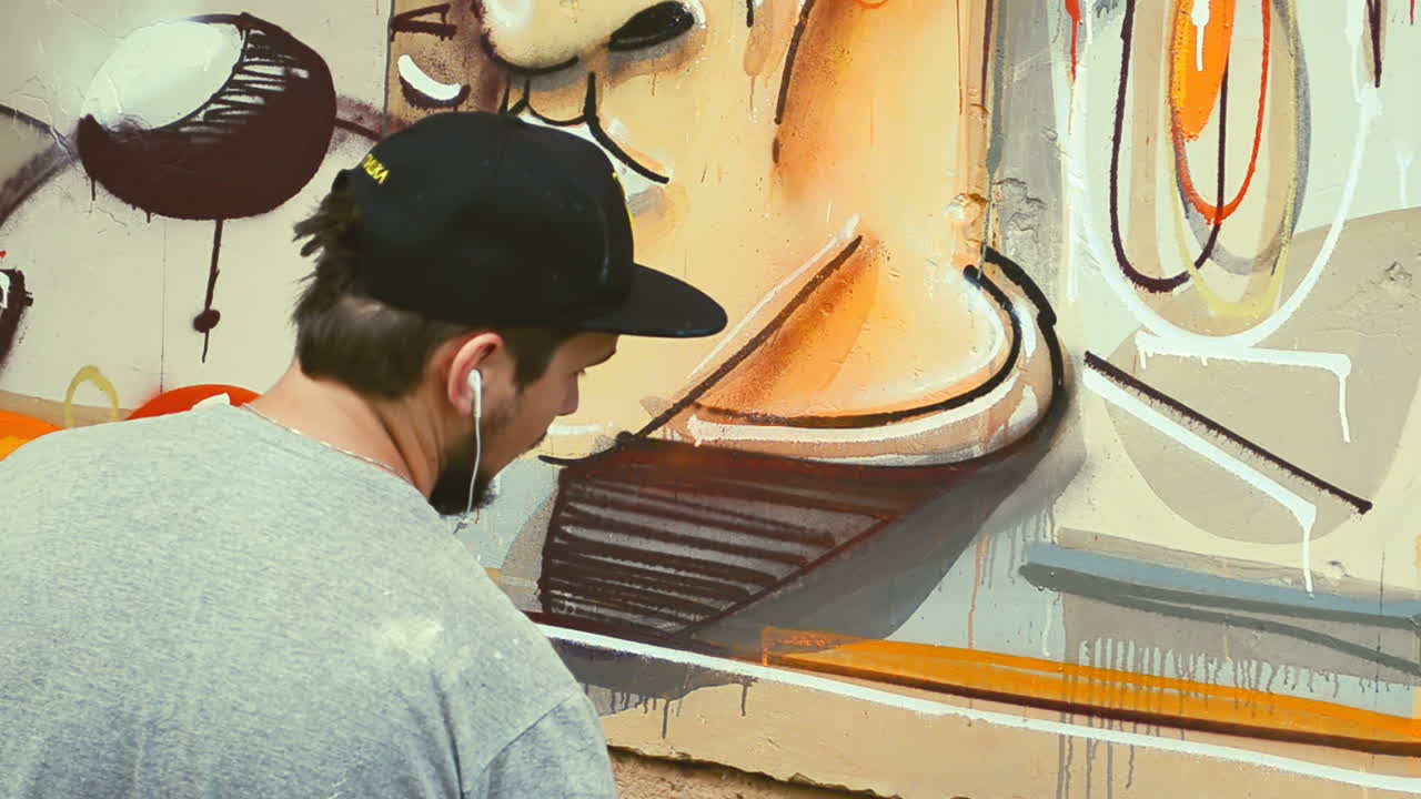 L'artista disegna graffiti su una recinzione. Graffiti su una recinzione.