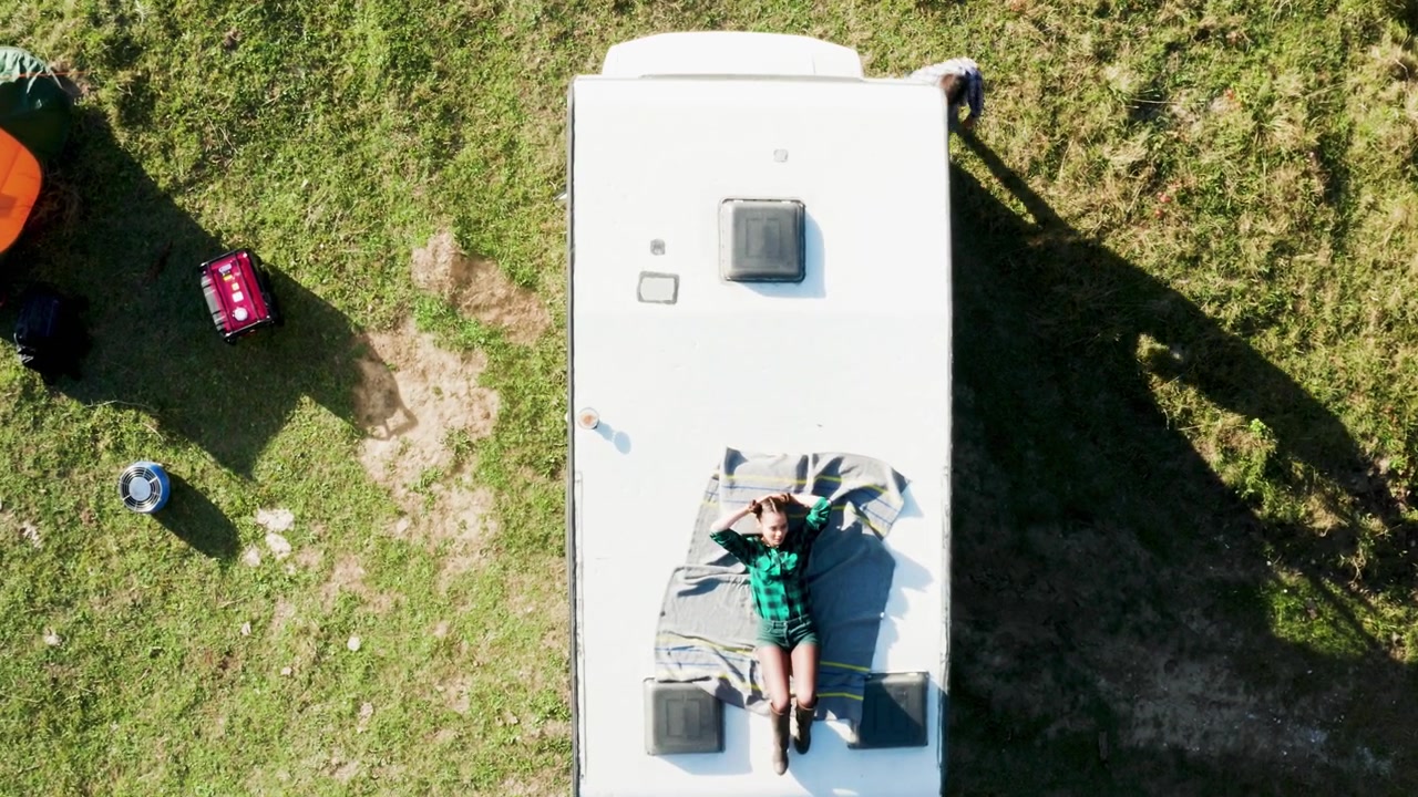 Un drone riprende una donna sopra il camper retrò