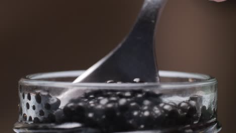 spooning caviar from a jar