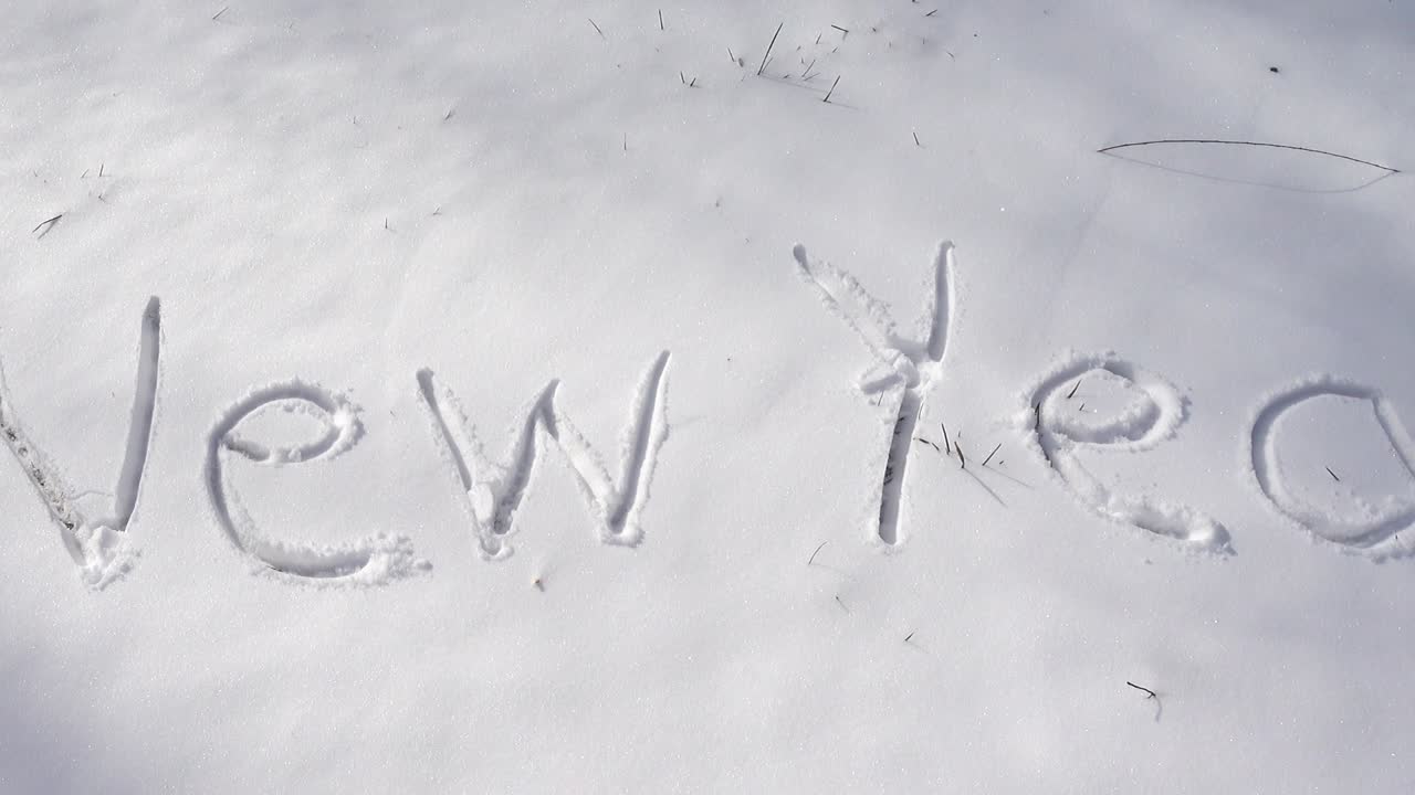 Inscription of happy new year on snow. Shooting in the winter