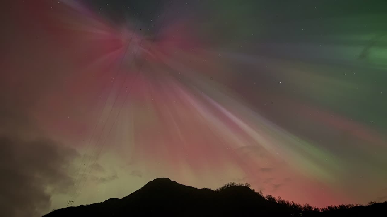 Stunning red, blue, yellow display of Aurora Borealis lights up night sky in Norway.