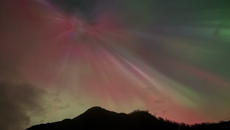 stunning red, blue, yellow display of aurora borealis lights up night sky in norway.