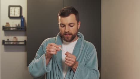 retrato de un joven cuidando sus uñas aplicando aceite