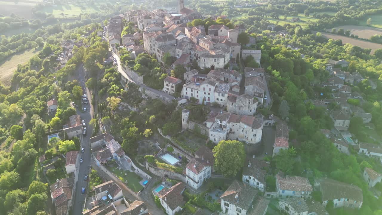 Drone aerial view in France countryside small old medieval brick town on a mountain top surrounded by green fields vertical panning on a sunny day in Cordes Sur Ciel