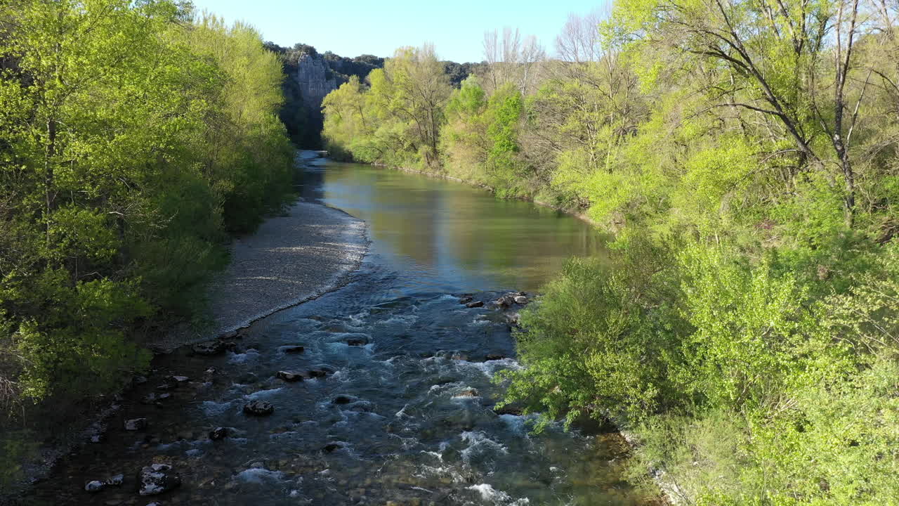 Scatto aereo del fiume Hérault nel sud della Francia, con foresta e alberi verdi in un giorno di primavera.