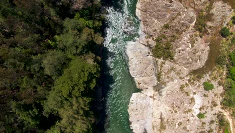 aerial: kawarau river flowing eastwards through a dramatic nature landscape in new zealand