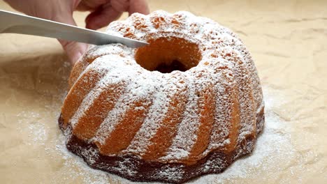 slicing the cake. traditional homemade marble cake. sliced marble bundt cake on paper. 4k resolution.