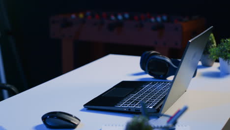 close up shot of personal office desk with laptop and headphones in living room