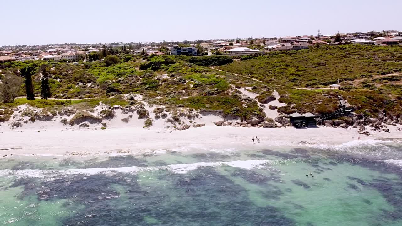 해변 애호가 들 은 바다 산호초 의  ⁇  모래 와 깊은 파란 물 을 즐기고 있다