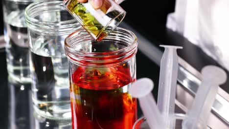 red liquid poured into clear water container