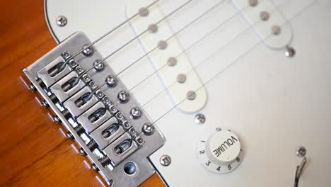 la mano del hombre levantando el potenciómetro de volumen de una guitarra eléctrica