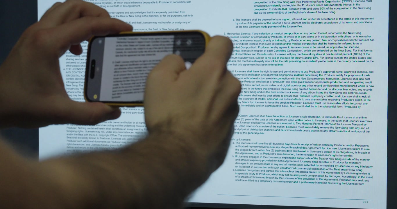 Close-up of a man secretly taking photos of confidential documents. Concept of data theft and security risk.