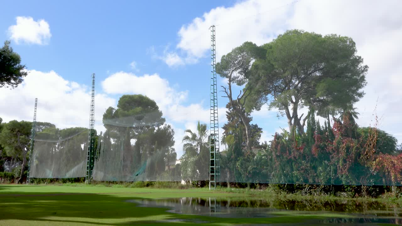 골프장 내 네트, 보호망이 설치된 출구, 인접 주택, 소나무 및 웅덩이