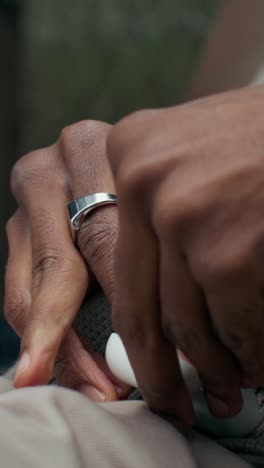 hands with ring and earbuds