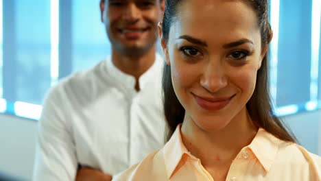 Business-colleagues-standing-together-with-arms-crossed-in-office