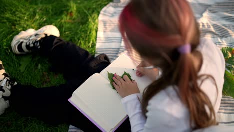 girl drawing with leaf on grass