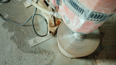 the builder drills holes in the concrete curtain for laying ventilation pipes and plumbing