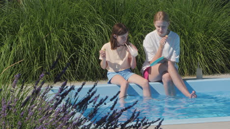 two girls enjoying a summer day by the pool