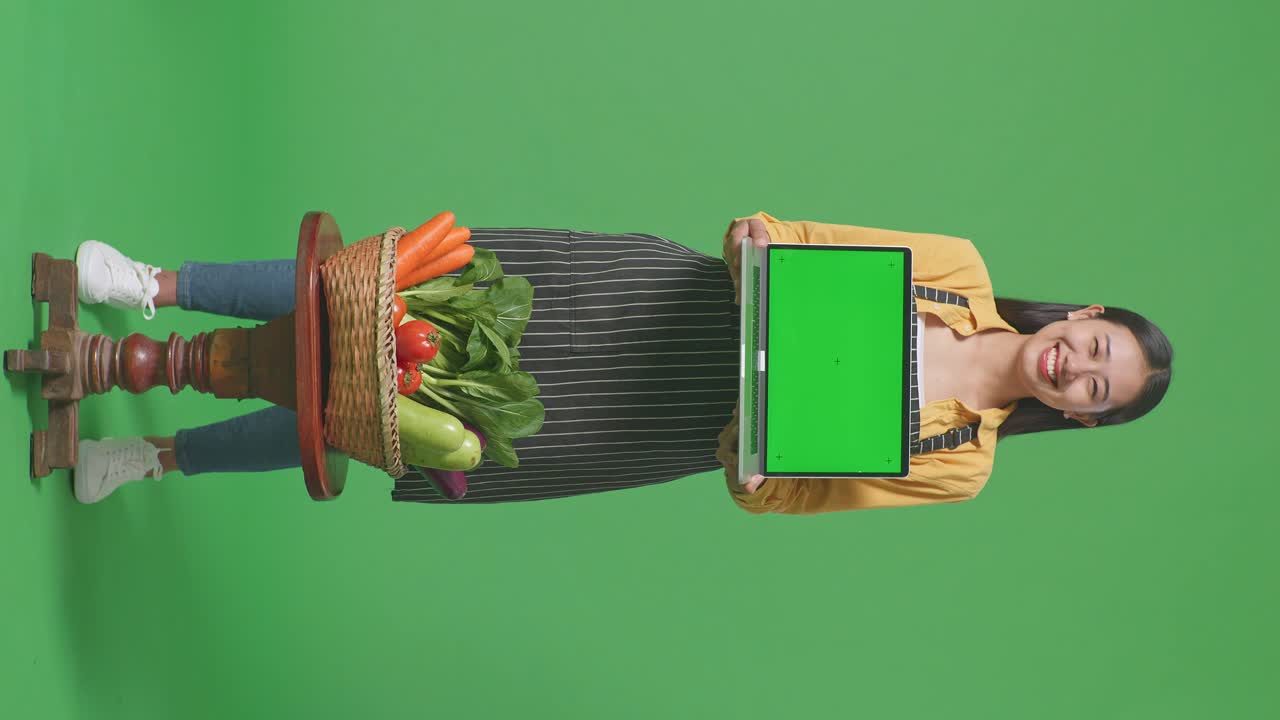 mujer mostrando una computadora portátil con productos frescos