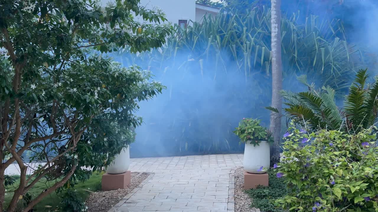 Ongediertebestrijder spuit muggenwerend middel rond het terrein van een luxehotel in Zanzibar, Tanzania